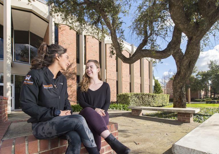 two students sitting on campus